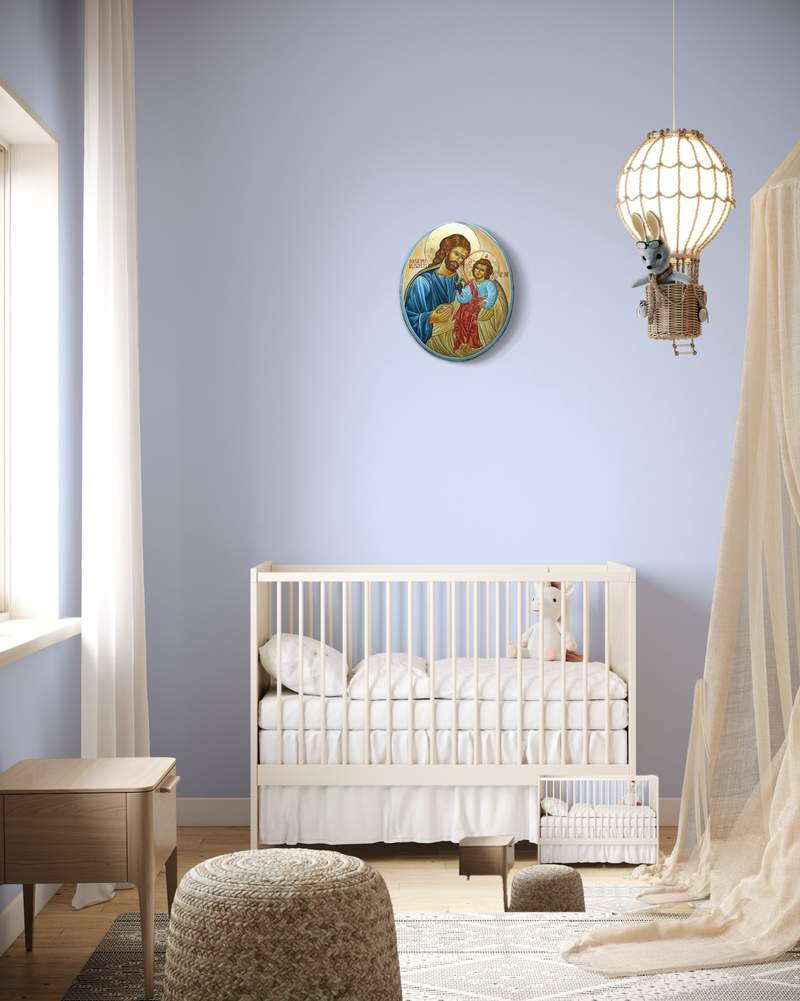 Oval icon of Saint Joseph with the Child Jesus above the cradle in a nursery