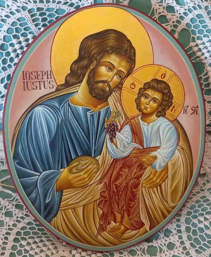 Oval icon of Saint Joseph the Nourisher painted by Concetta Basile: Joseph offers the bread, the Child Jesus holds a bunch of grapes; Latin inscription IOSEPH IUSTUS